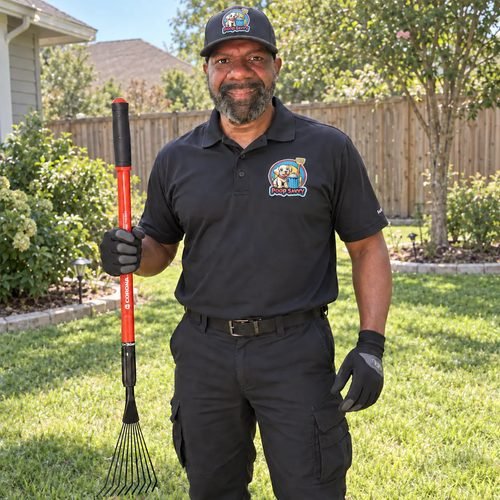 Josh Reed of Poop Savvy in a black company polo and cap, holding a scoop rake in a customer's back yard